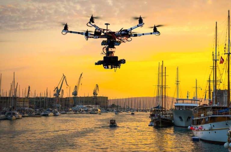 Een drone vliegt boven een havenstad aan het water