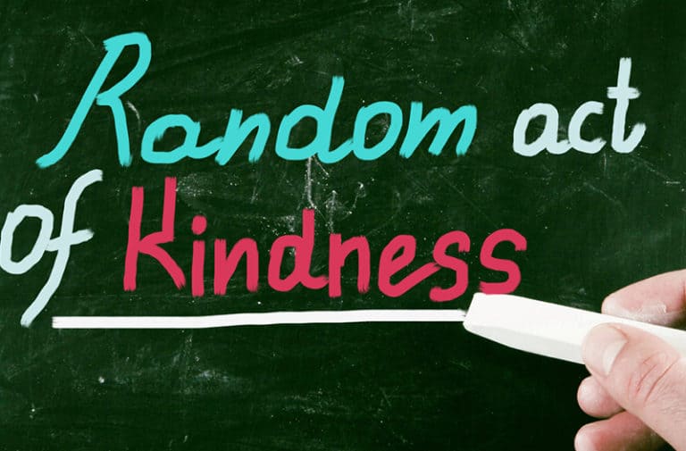 Een groen schoolbord met de tekst “Random act of kindness”