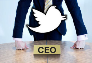 Een man in een pak leunt op een ronde houten tafel met het woord ‘CEO’ waarboven het Twitter-logo zweeft