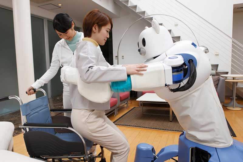 Robot helpt Aziatische vrouw opstaan uit rolstoel