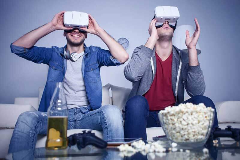 Twee mannen met VR headsets zitten op de bank