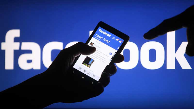 Persoon houdt smartphone vast met Facebook op het scherm