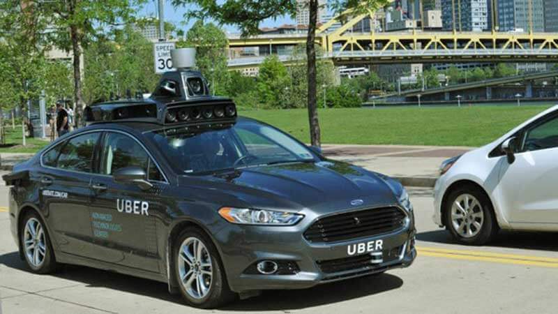 Uber-ingenieur en chauffeur in een zwarte zelfrijdende Ford Fusion