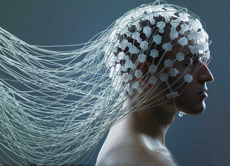 Bedrade elektroden van een hersencomputerinterfacesysteem bevestigd aan het hoofd van een man