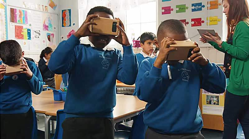 Een klaslokaal vol met kinderen met Google Cardboard VR-headsets op hun hoofd