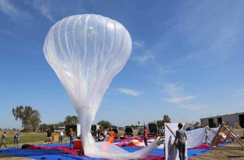 balloon taking off into a bright blue sky