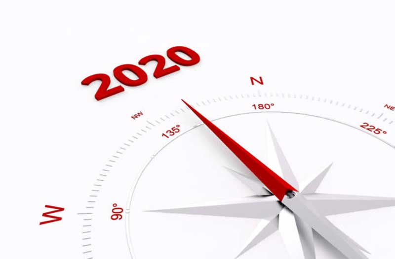 A white compass with a red needle pointing at ‘2020’ written in red