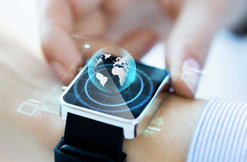 A smartwatch on a person’s wrist with a hologram of planet Earth hovering above it