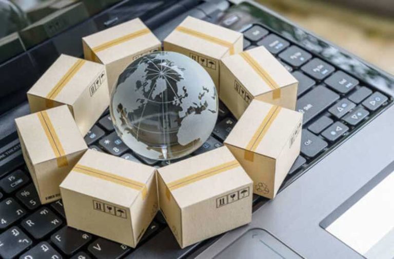Een kleine glazen wereldbol op een keyboard omgeven door kartonnen doosjes