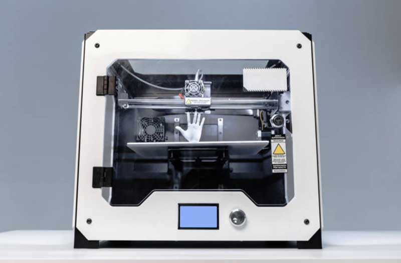 3D printer with white plastic hand inside