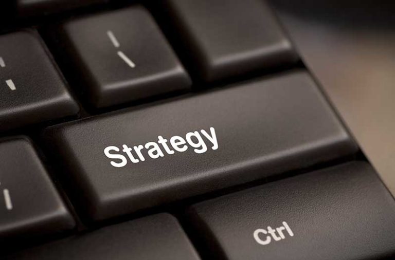 Een closeup van een keyboard met op een van de toetsen het woord ‘strategy’