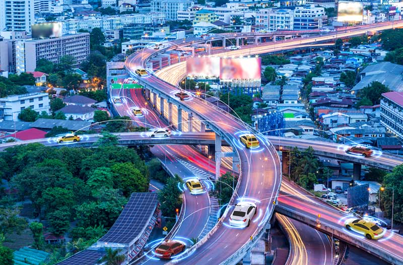 Stad met gekleurde digitale snelwegen met zelfrijdende auto’s