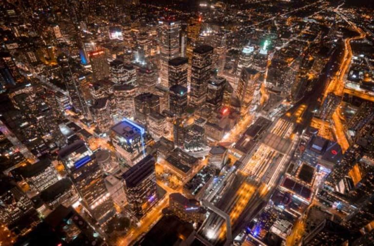 Een luchtfoto van een verlichte stad bij avond
