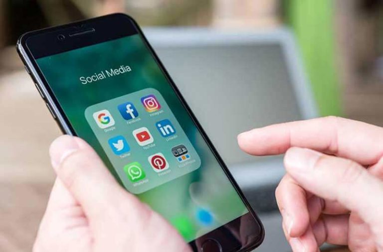 Twee handen bedienen een smartphone met social media iconen