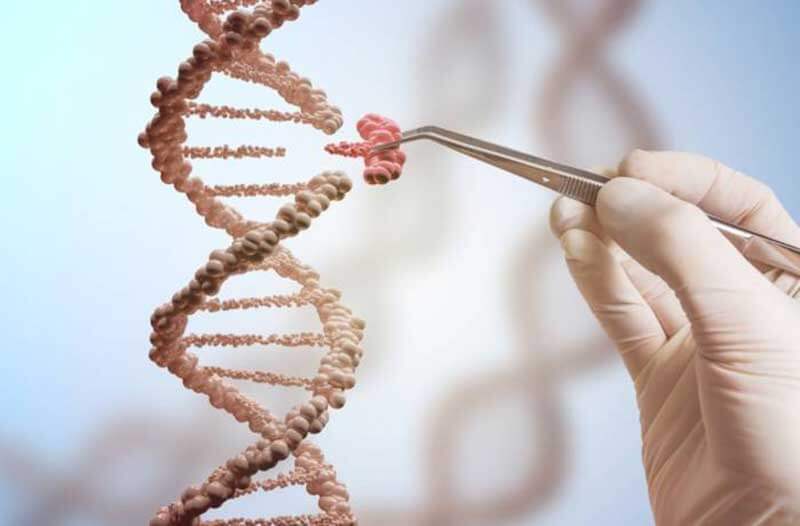 Een hand met medische handschoen en een pincet knipt een stukje DNA