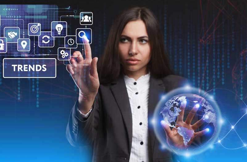 A woman interacts with a holographic interface with her right hand, while the left one is placed over an icon of planet Earth
