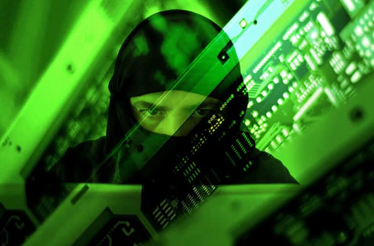 Groen computerscherm met een weerspiegeling van een man in een zwarte hoodie