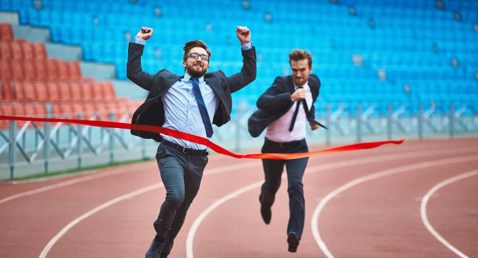 Businessman in suit running with hands up in the air winning a marathon
