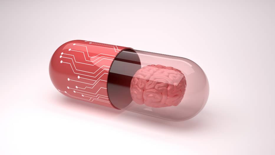 Red transparent capsule with digital images and a brain model