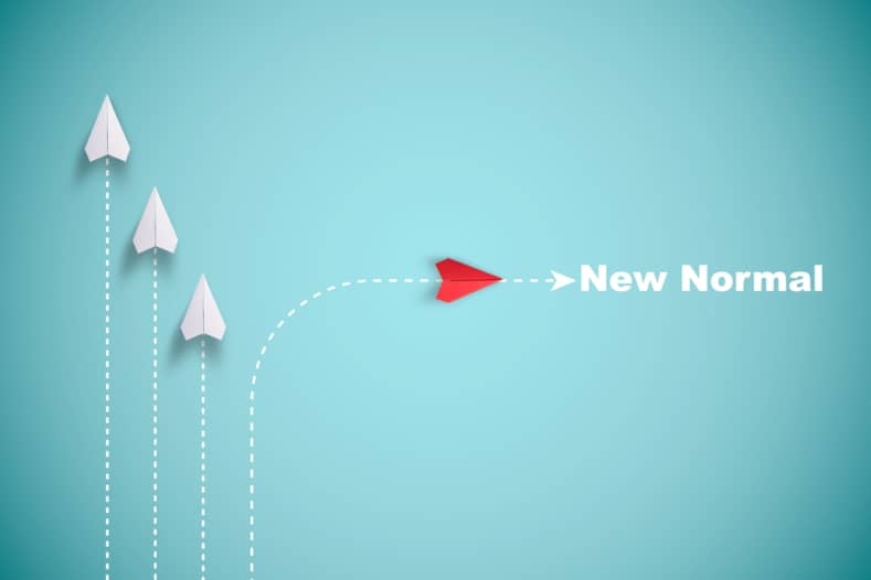 Three white paper planes and one red one with the words ‘now’ and ‘normal’