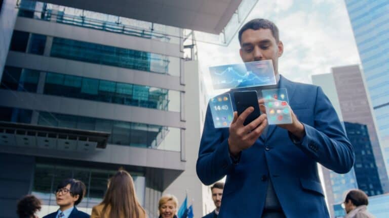 Een man in een blauw pak staat midden in de stad en kijkt op zijn smartphone, terwijl virtuele financiële infographics boven zijn hoofd zweven.