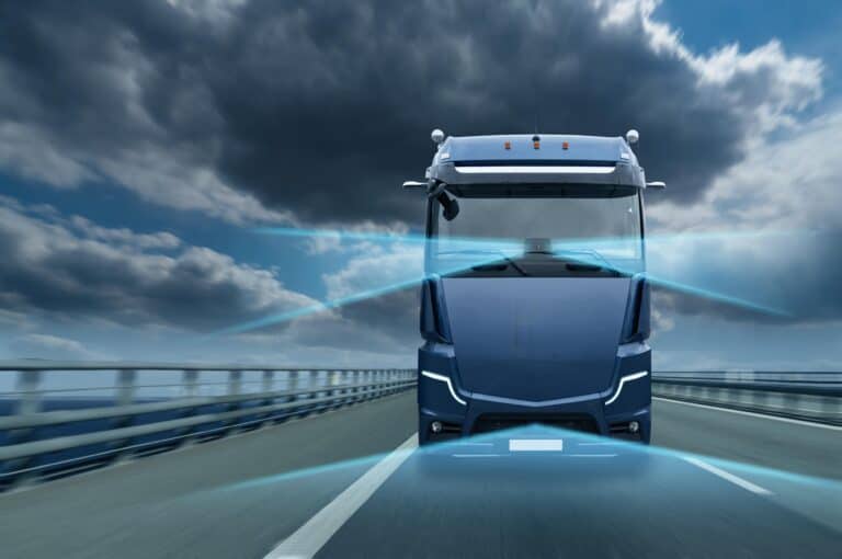 Een futuristisch ogende vrachtwagen op een snelweg met op de achtergrond een donkere bewolkte lucht.
