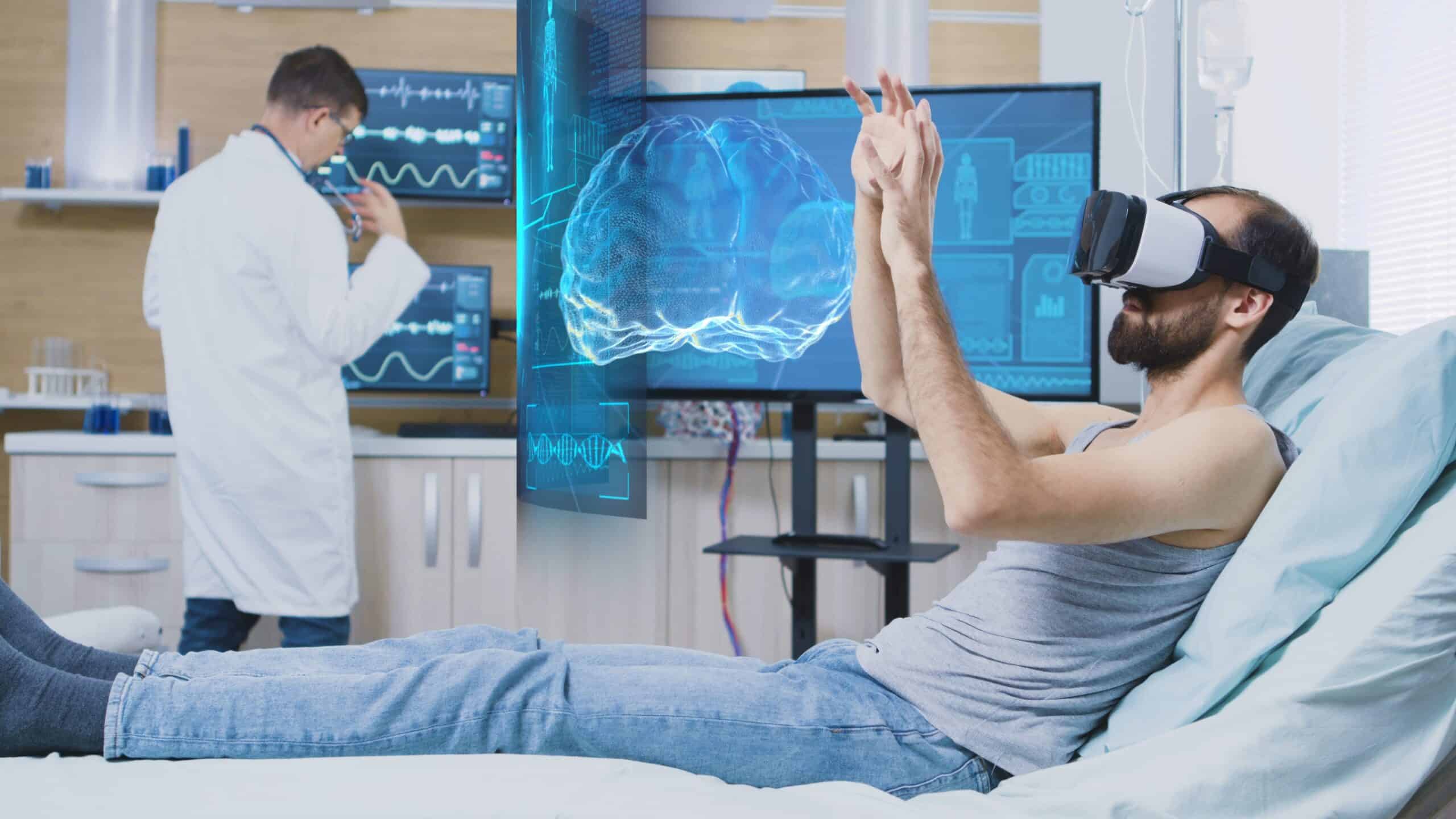 A man is lying in a hospital bed wearing a VR headset and manipulating a virtual screen floating in front of him. Next to him is a doctor and a screen showing medical infographics