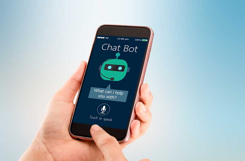 Hand holding cell phone with chatbot icon on screen