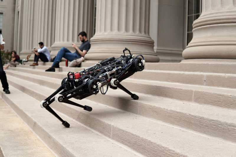 A four-legged black robot called The Cheetah climbing stairs