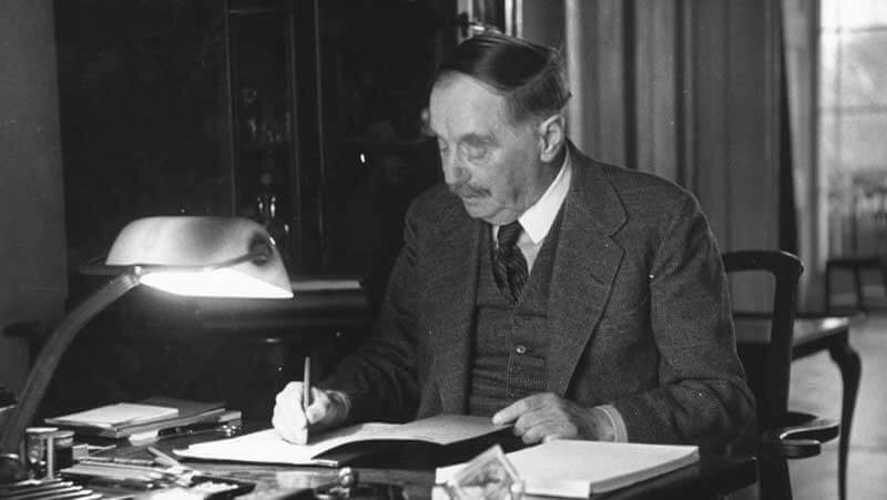 Black and white photo of H.G. Wells sitting at his desk and writing
