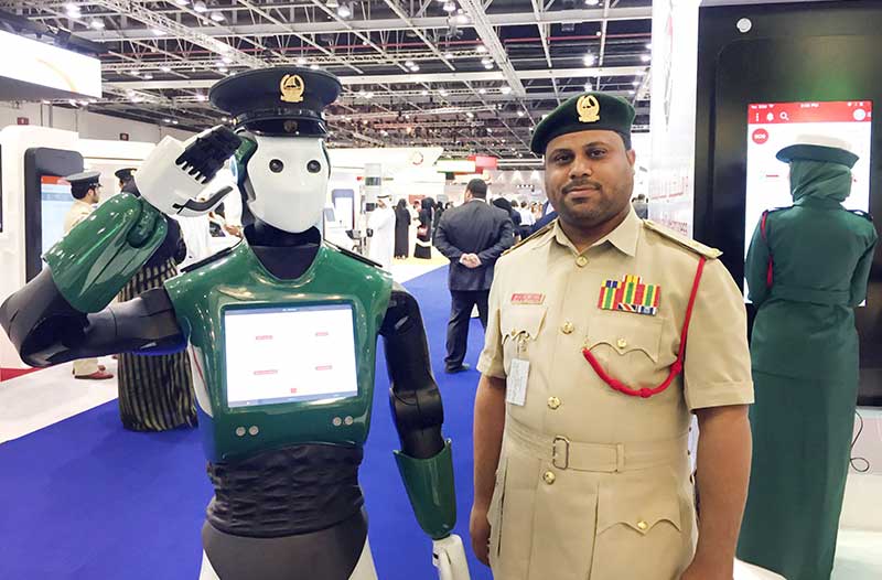 A police robot and a human police officer standing next to each other