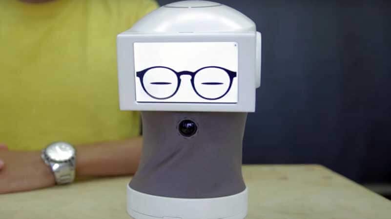 small robot equipped with illustrated glasses standing in front of a person