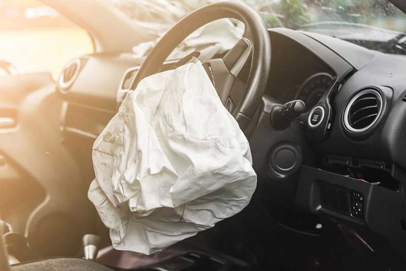 The inside of a car with a deployed airbag system after a crash