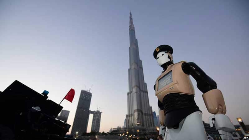 A humanoid robotic police officer standing in front of the Burj Khalifa building in Dubai