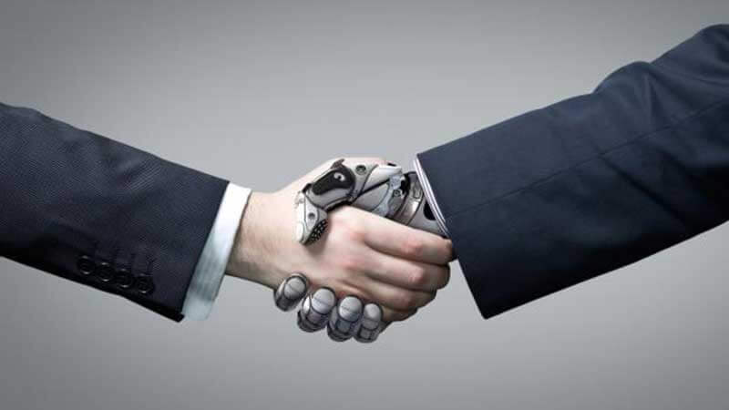 A handshake between a robotic and a human hand both dressed in business suits