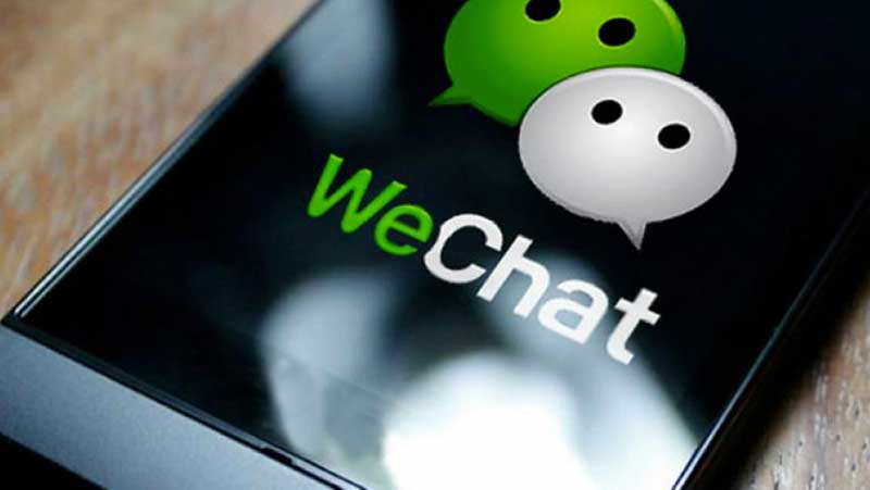 A close-up picture of a smartphone with the WeChat app icon displayed on its screen
