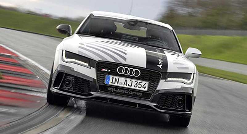 Fast driving autonomous black & white Audi on the road