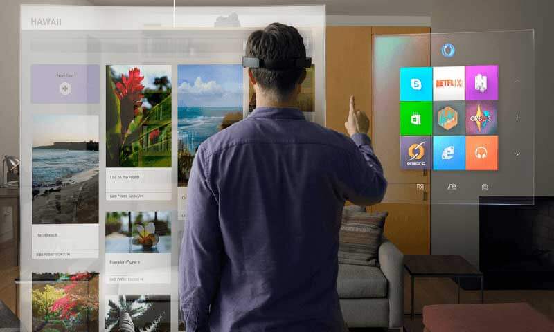 A man wearing a mixed reality headset in his home interacts with a digital interface 