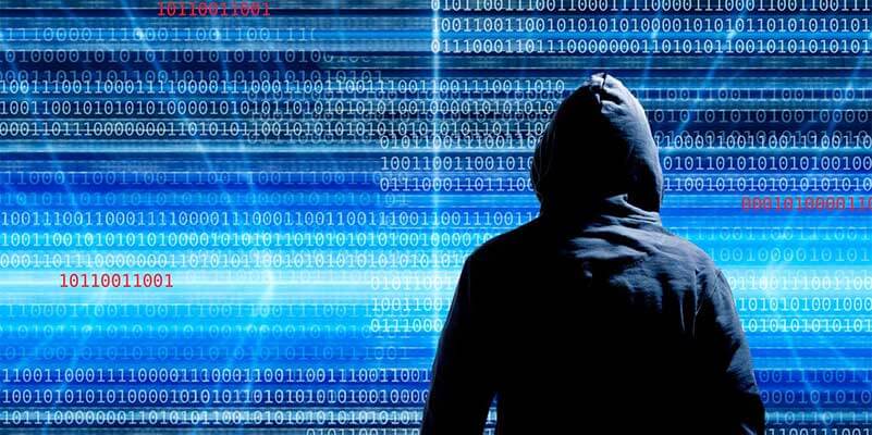  Person with black hoodie in front of blue screen with binary code