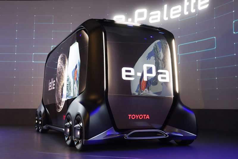 Toyota’s e-Palette, a box-shaped black vehicle on eight wheels