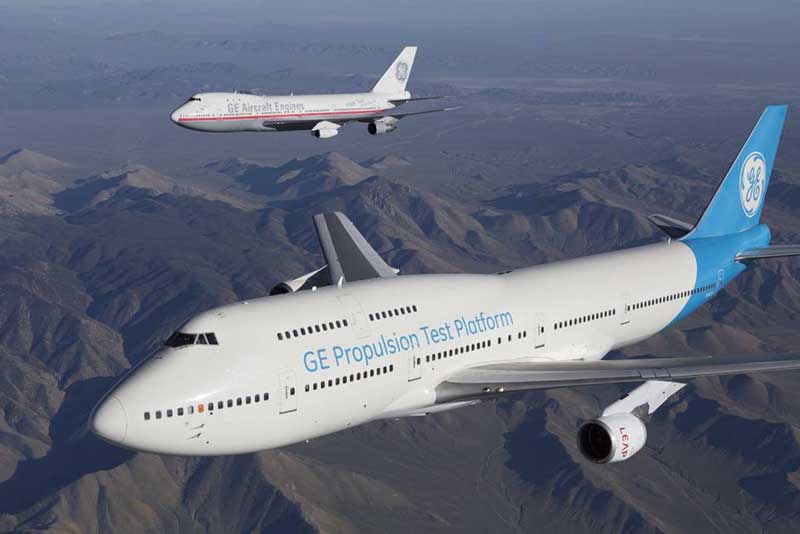 Two GE planes flying over mountain peaks