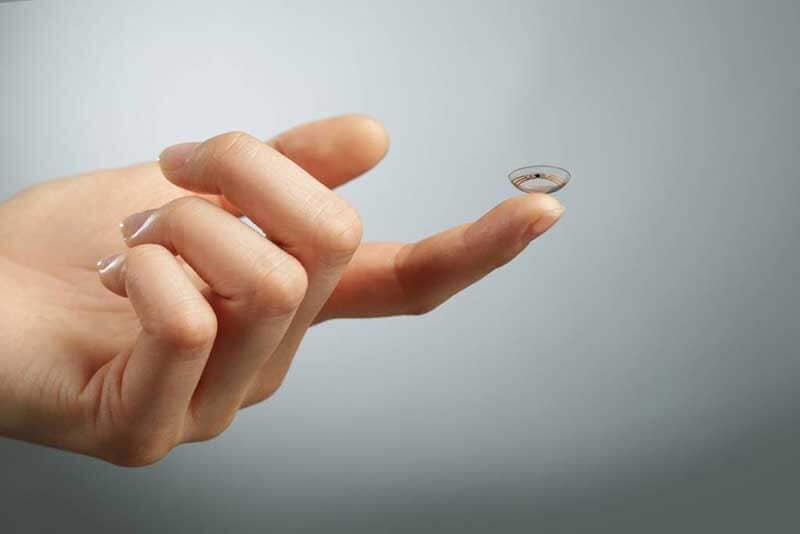 A hand holding Google’s contact lense on the tip of its finger