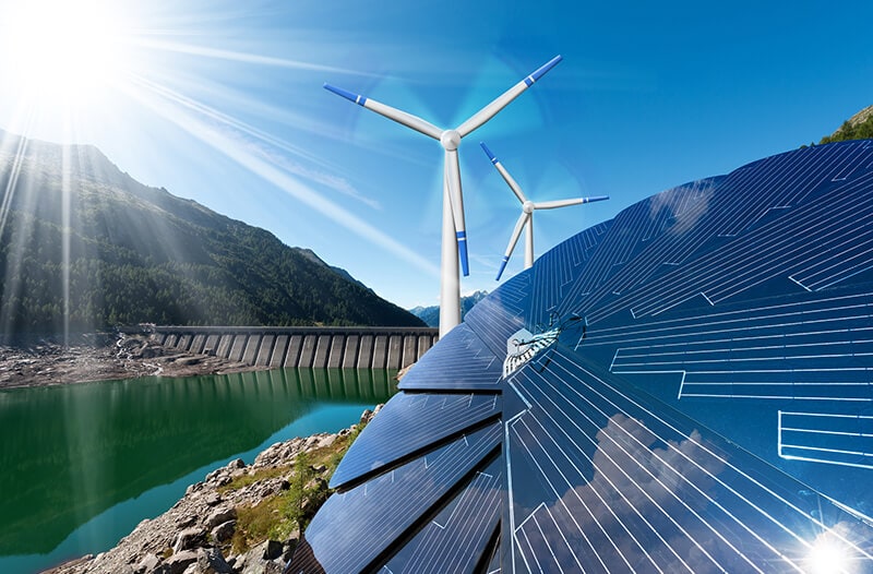 Wind turbines and solar panels in green landscape with mountain