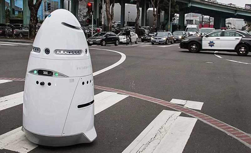 White cone-shaped robot rolling over zebra crossing