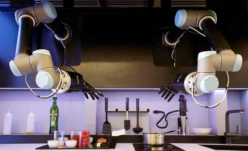 Two robot arms hovering above a kitchen stove