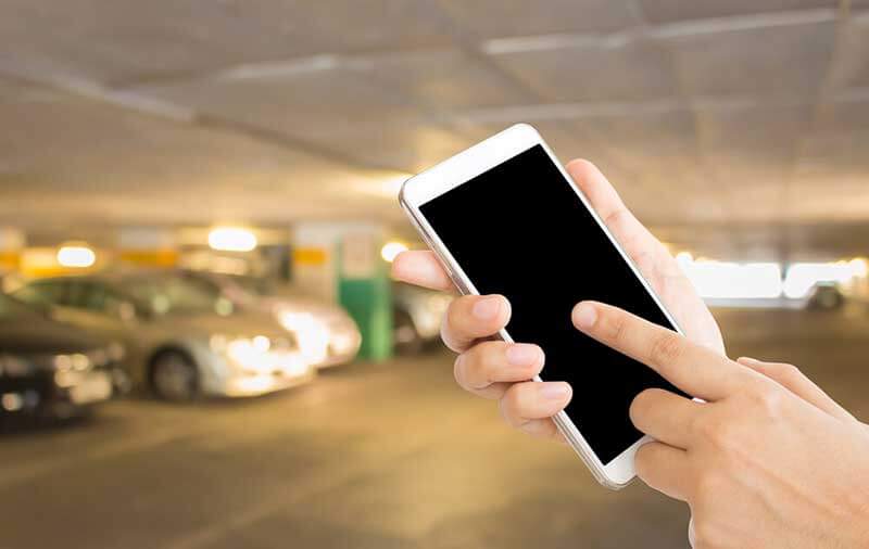 hands holding a smartphone in a parking garage