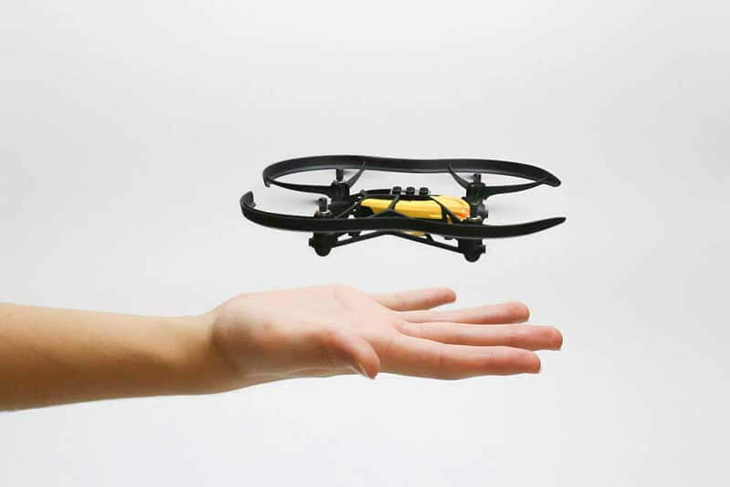 Hand facing up with a small drone hovering above it