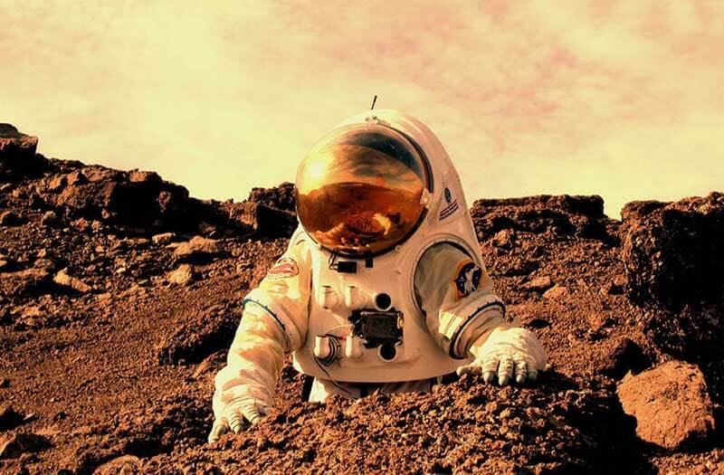 An astronaut in a space suit stands on mars