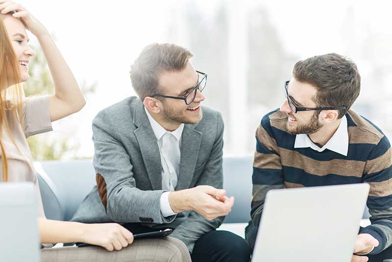 Two men and a woman having a meeting with laptop