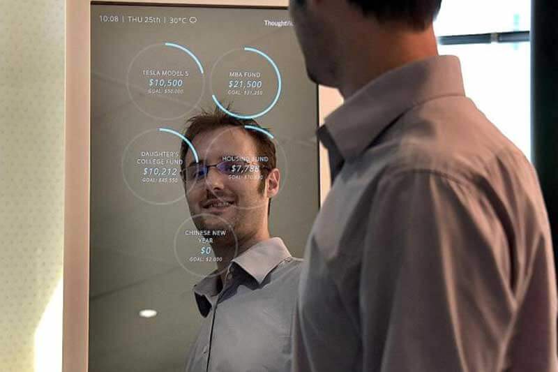Young man looking at himself in a mirror displaying financial information